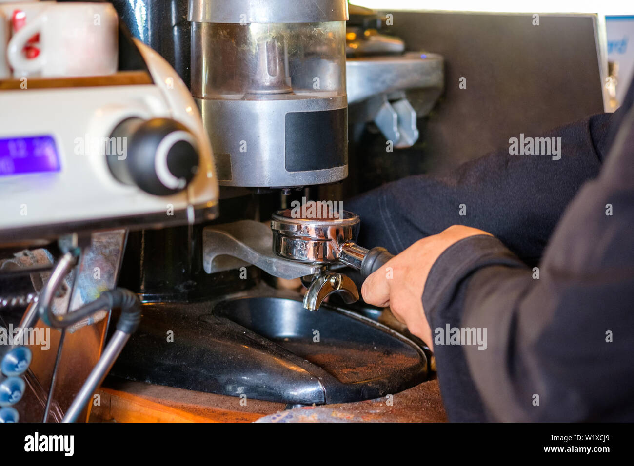 Mann Barista Kaffee mahlen Puder auf Kaffeemaschine Stockfotografie - Alamy