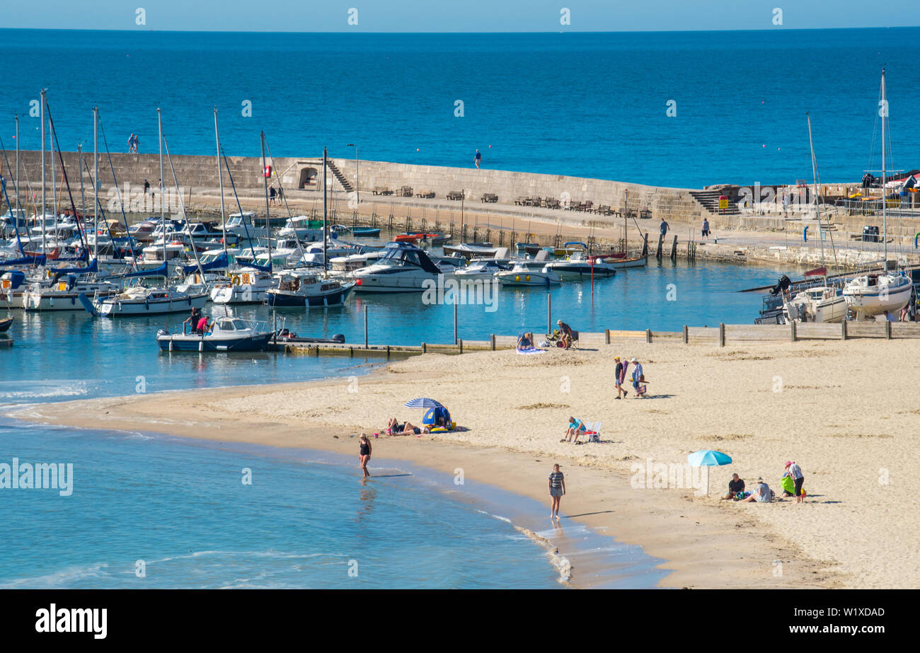 Lyme Regis, Dorset, Großbritannien. 4. Juli 2019. UK Wetter: Sonnenschein und blauer Himmel in den Badeort Lyme Regis. Frühe beachgoers sicher einen Punkt auf den hübschen Sandstrand in Lyme Regis am Donnerstag Morgen. Credit: Celia McMahon/Alamy Leben Nachrichten. Stockfoto