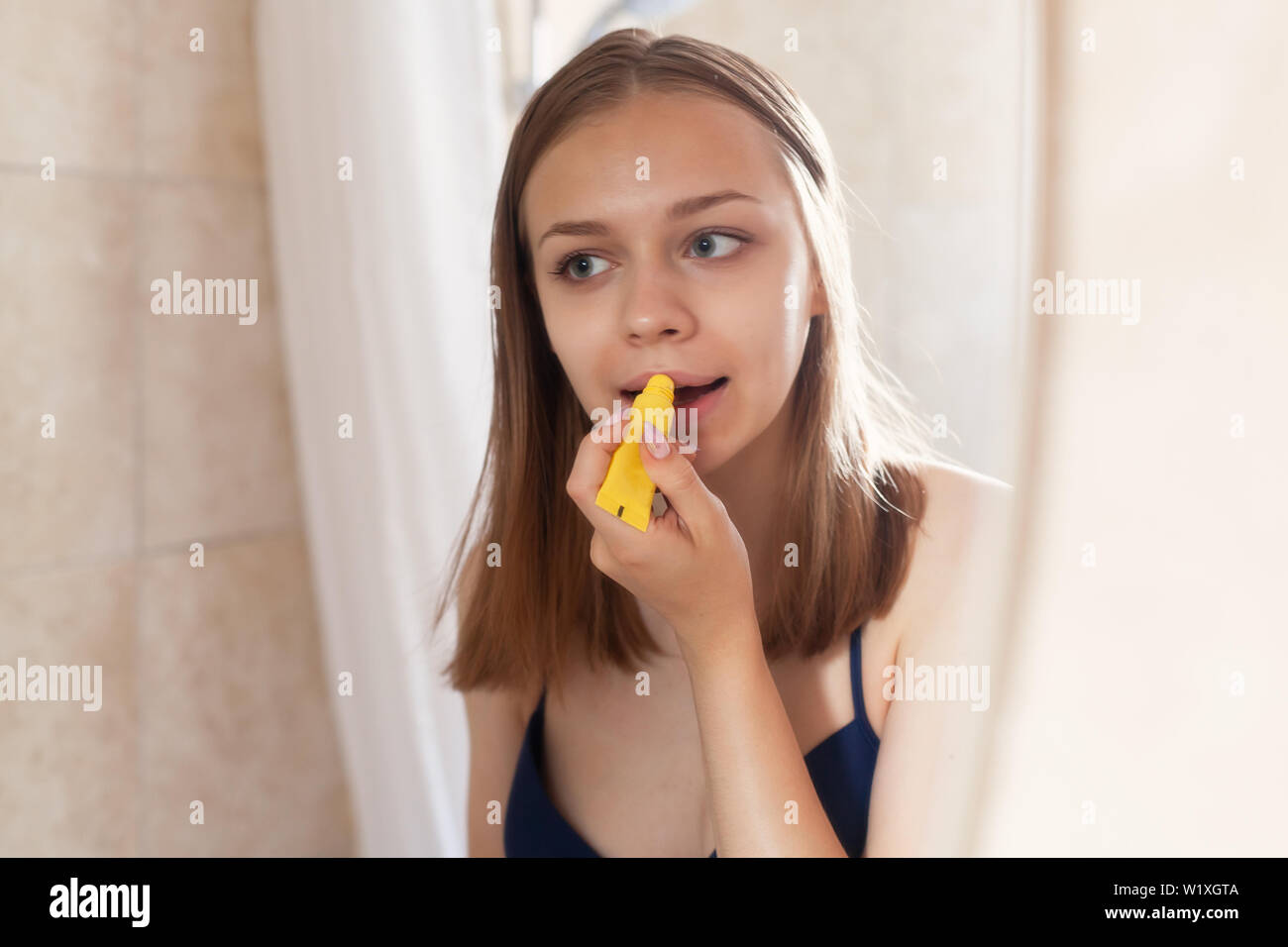 Junge schöne Blondine kaukasische Mädchen macht Verfahren mit schützender lip Teekocher Stockfoto