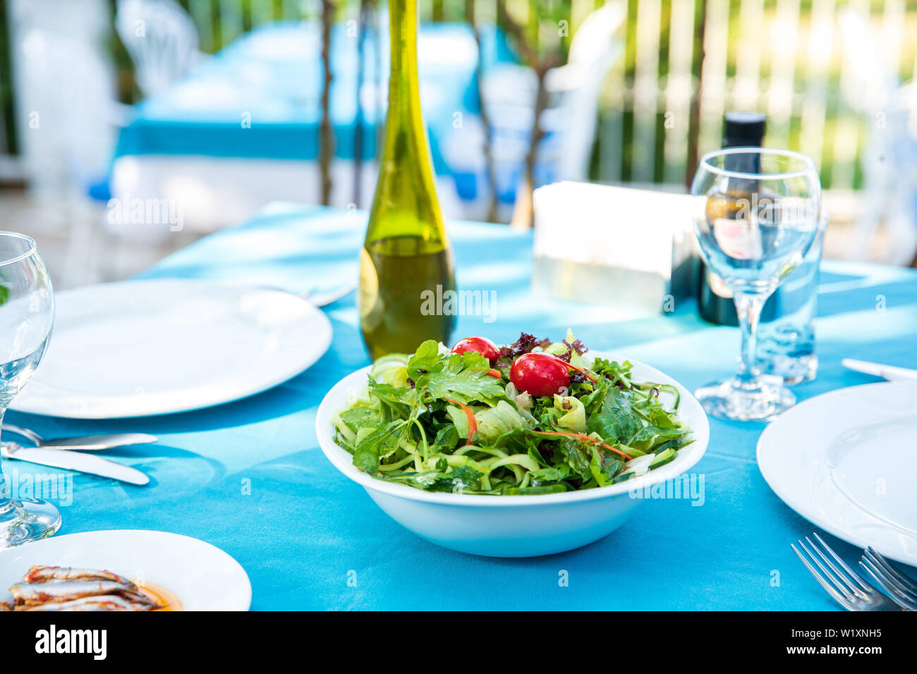 Griechisch, Mediterran oder Ägäis grüne Frische vegetarische Salat auf den Tisch im Fisch Restaurant. Grüner Salat in der Schüssel mit Olivenöl im Beach Restaurant Stockfoto