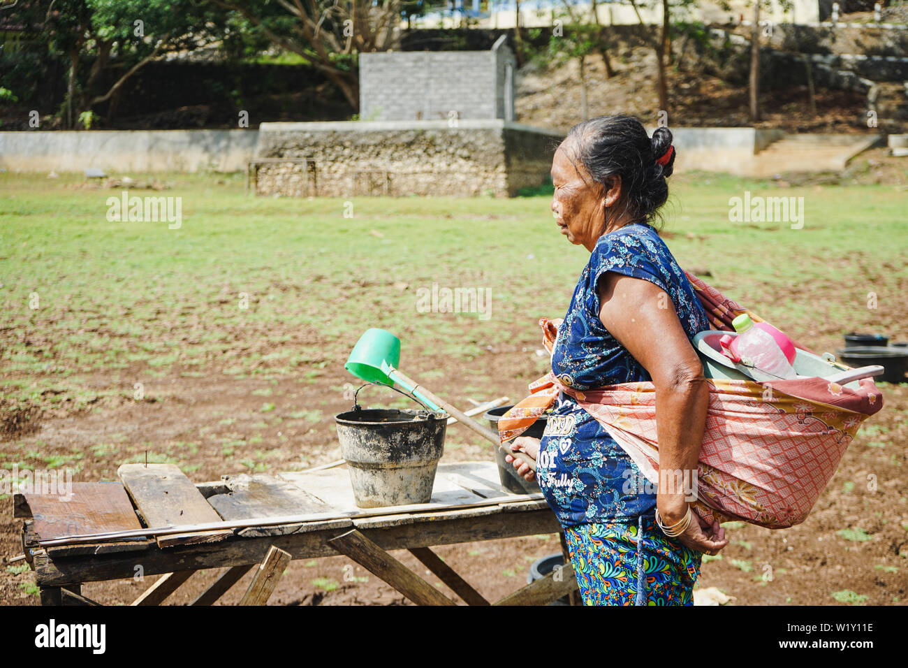 Frau nehmen Wasser aus einer Quelle in Dosen, wenn trockene Jahreszeit in Gunungkidul, Yogyakarta, Indonesien, 21. Juli 2017. Stockfoto
