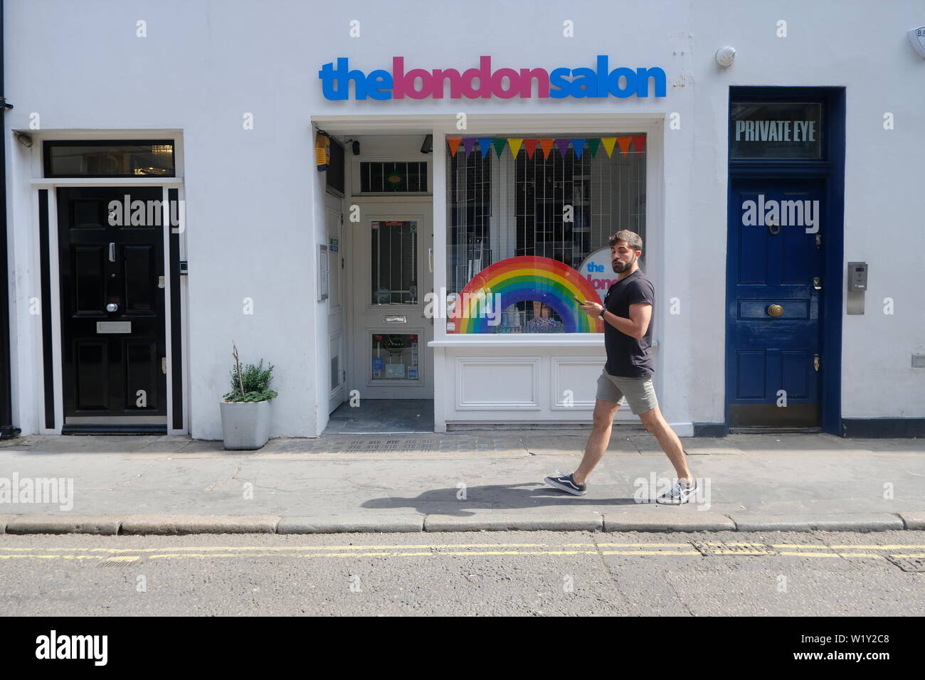 Der London Salon, Soho Shop Front mit Passanten und Regenbogen im Fenster Stockfoto