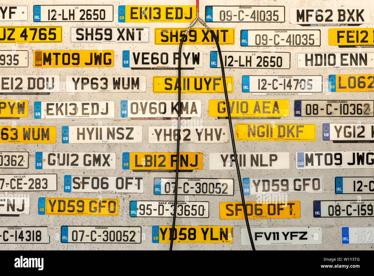 Alte verworfen, britischen und irischen Lizenz Anzahl Platten auf Auto service Wand angezeigt. Stockfoto
