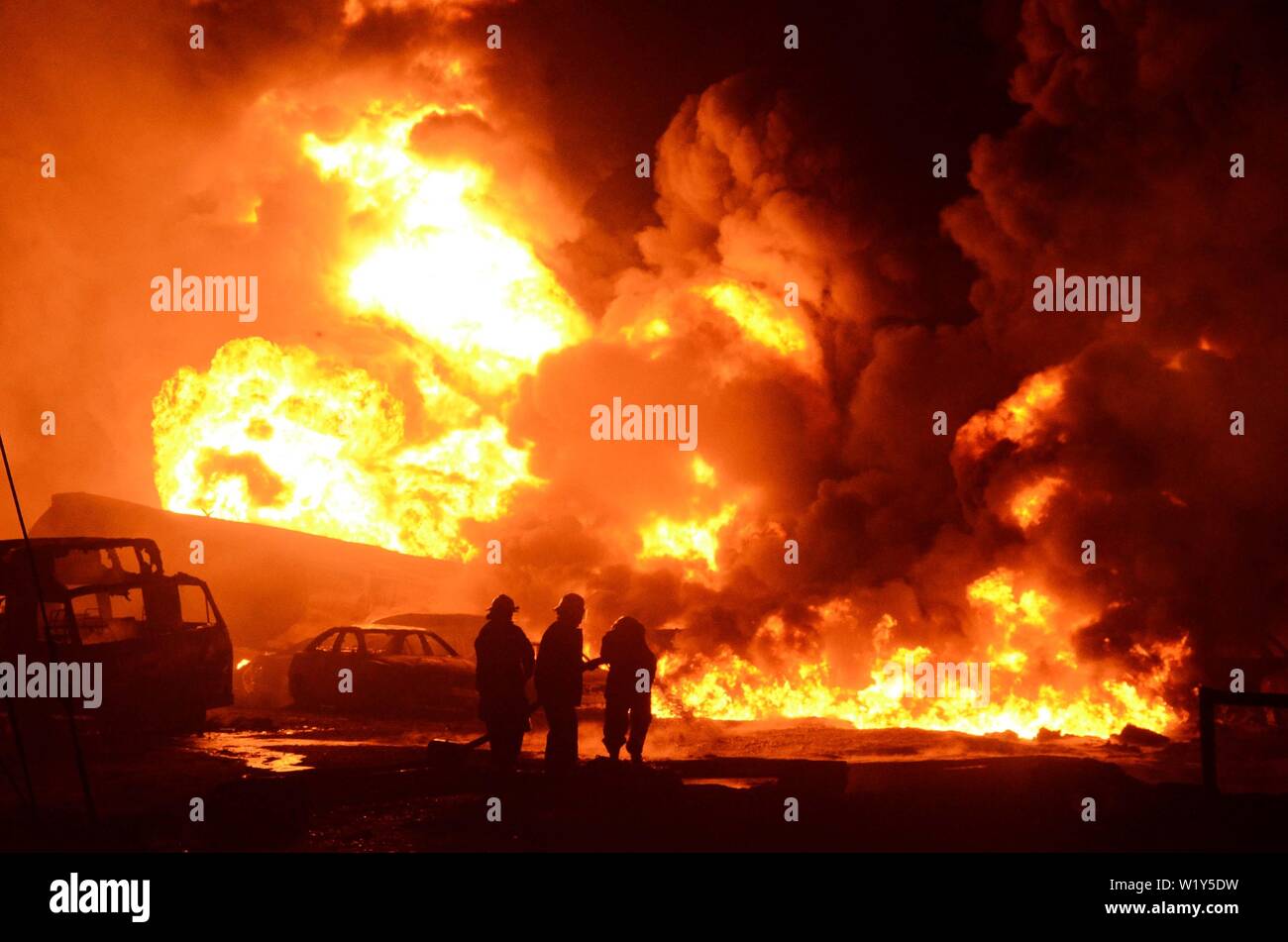 (190704) - Lagos, 4. Juli 2019 (Xinhua) - Feuerwehrmänner arbeiten auf Löschen eines Brandes durch eine Ölleitung Explosion in Ijegun Stadt verursachte, Sat-Stadt Lagos, Nigeria, am 4. Juli 2019. Brand, der durch eine Ölpipeline explosion Donnerstag in einem Satelliten Stadt Lagos, wirtschaftliche Drehscheibe in Nigeria verursacht, ist nach Angaben der Landesregierung in Lagos. Der Brand, der entlang des Staates eingetreten - run Öl Pipeline des Unternehmens unter Ijegun Stadt um 5 Uhr, wurde angeblich durch Vandalen, die Öl stehlen aus der Pipeline verursacht wurden, die Landesregierung sagte in einer Erklärung. (NAN über Xinhua) Stockfoto