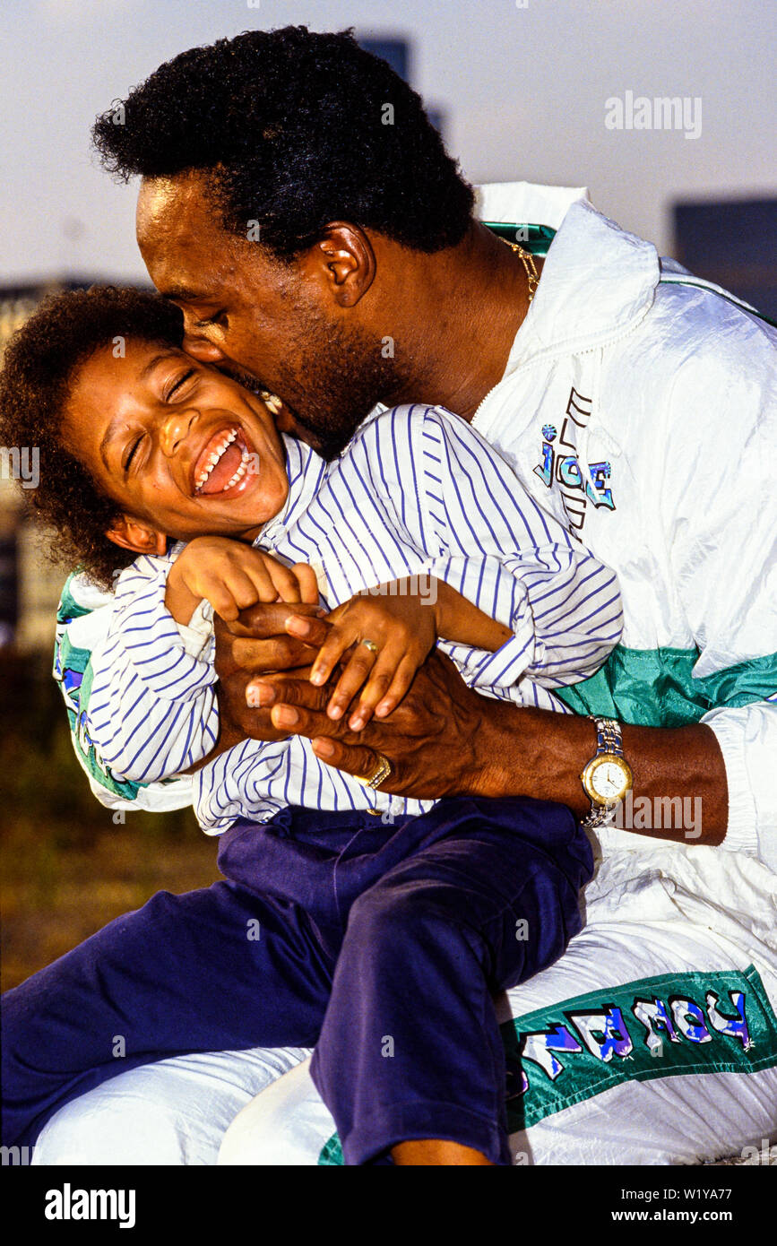 London, 1990. Portrait von Boxer Nigel Benn mit seinem Sohn Dominic. Den Spitznamen der Dunkle Zerstörer, er hielt den WBO-Titel im Mittelgewicht 1990, und den WBC Stockfoto