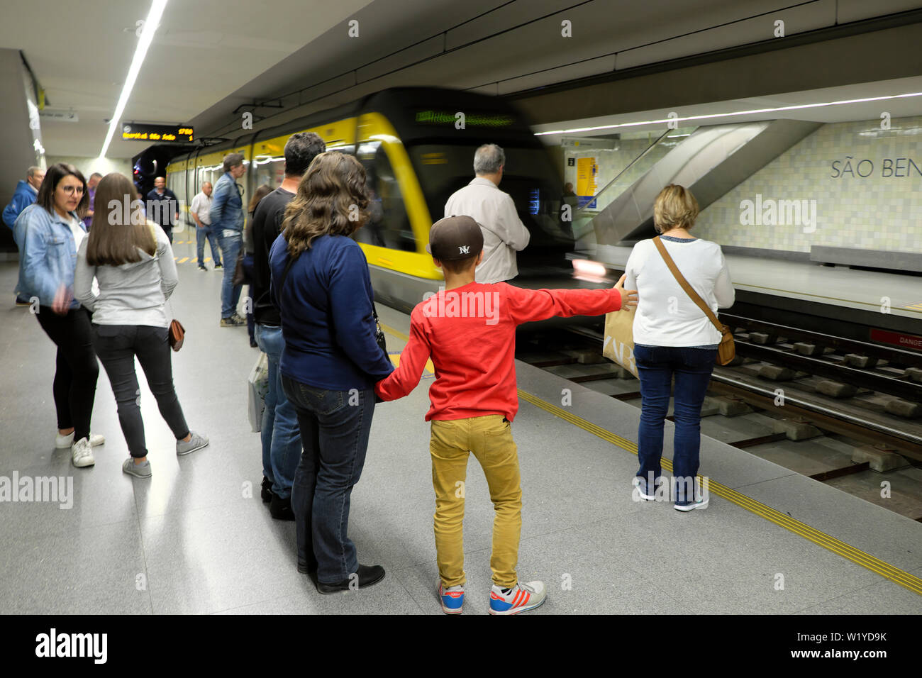 'S Mutter holding Junge Kind hand auf Plattform wartet mit Passagieren als U-Bahn Ansätze in Porto Porto Portugal Europa KATHY DEWITT Stockfoto