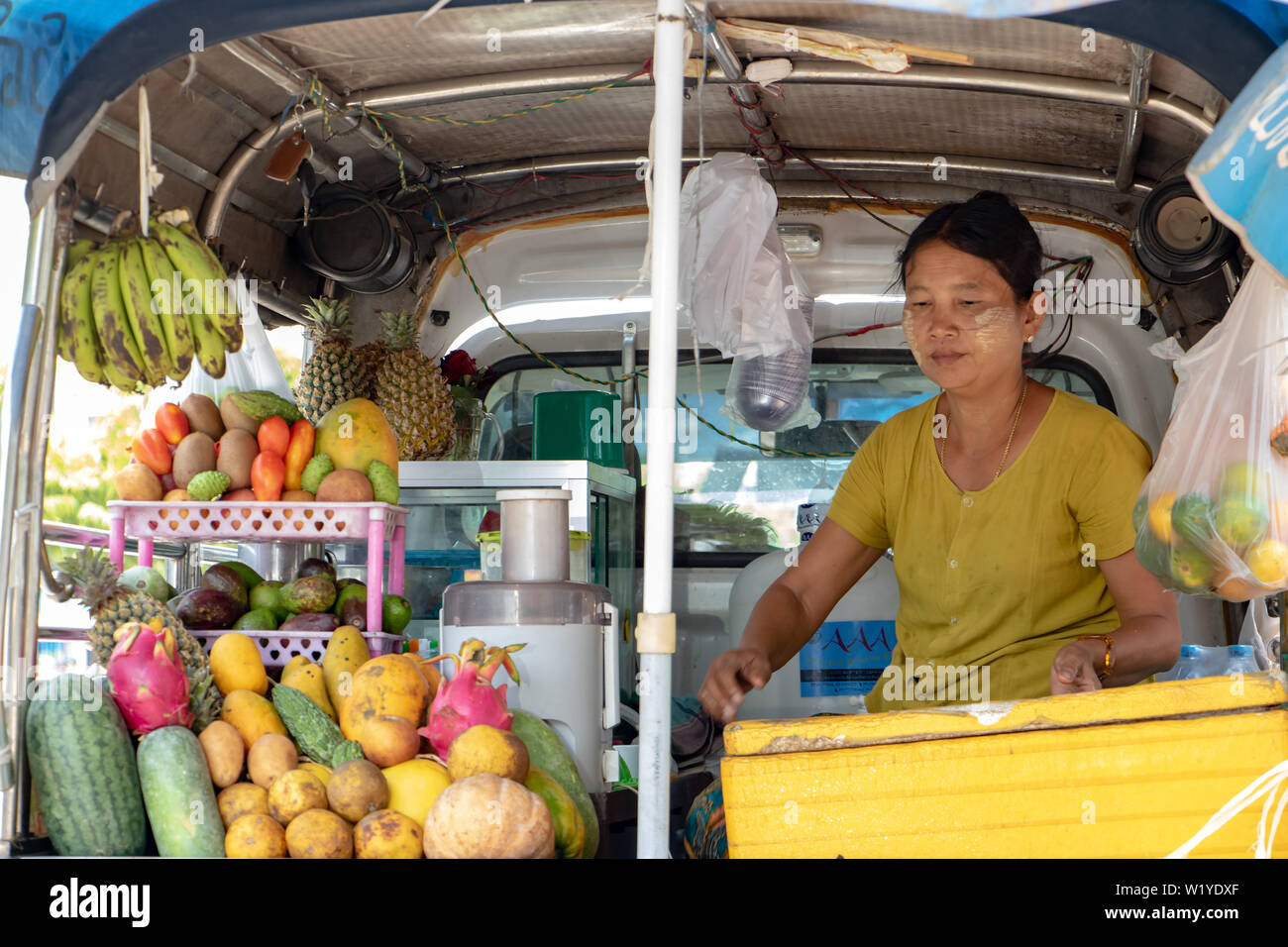 MANDALAY, Myanmar, 20. Mai 2018, asiatische Frau verkauft frisches Obst Getränke. Verkauf von Erfrischung in der Straße von einem Mobile Shop auf einem Auto. Stockfoto