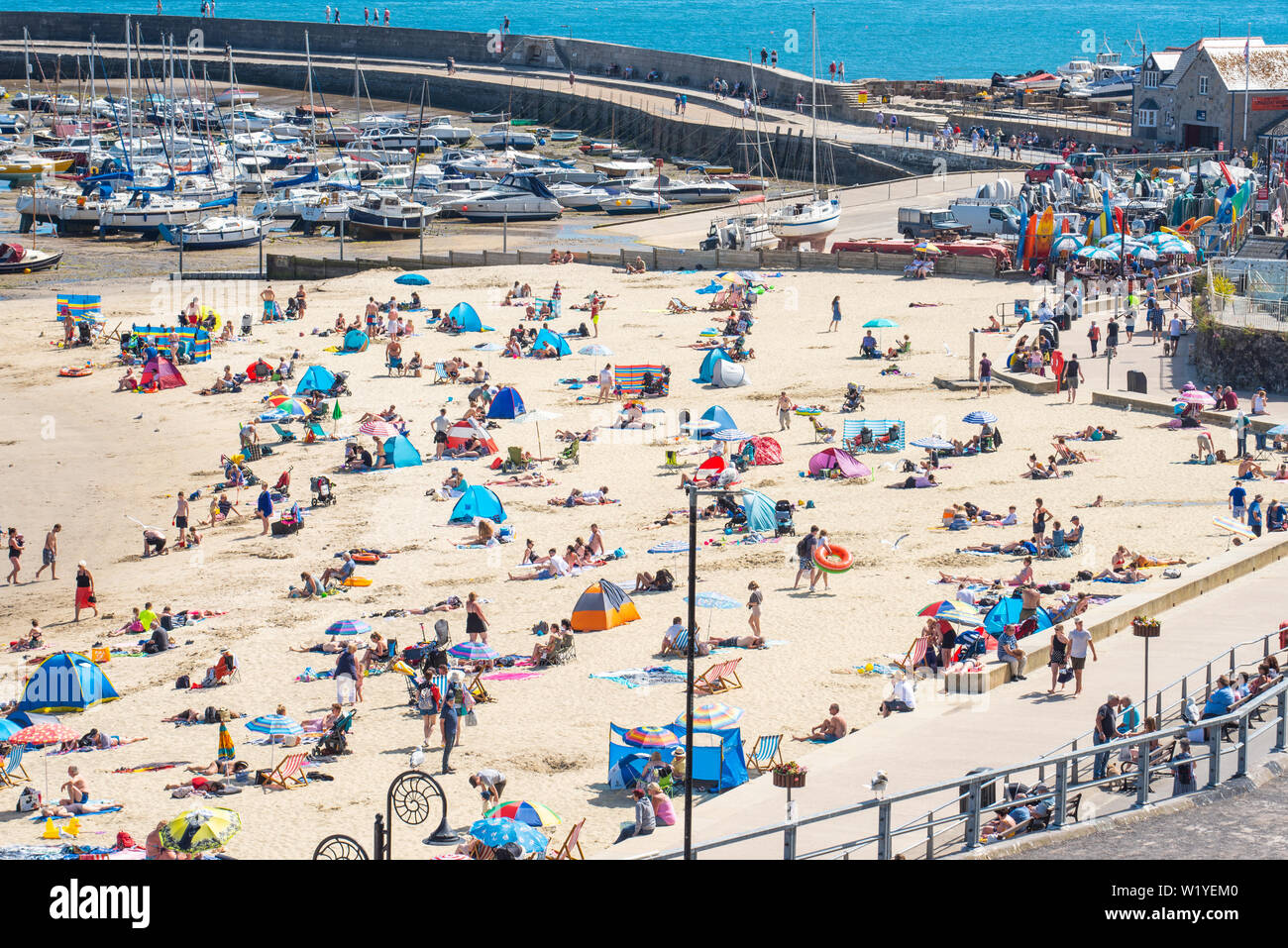 Lyme Regis, Dorset, Großbritannien. 4. Juli 2019. UK Wetter: Der Strand im Badeort von Lyme Regis besetzt war heute Nachmittag als Sonnenanbeter genossen die glühend heiße Sonne und blauen Himmel. Credit: Celia McMahon/Alamy Leben Nachrichten. Stockfoto