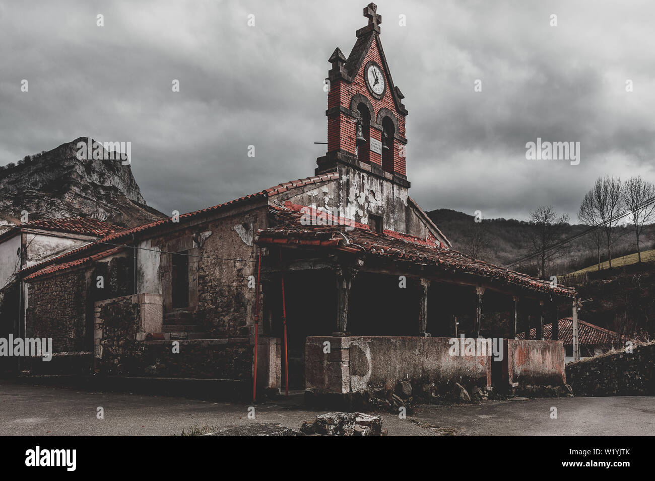 Alte Kirche zwischen den Bergen des Naturparks von Ponga in Viego, Asturien, Spanien. in Stein, Holz und rotem Backstein gebaut Stockfoto