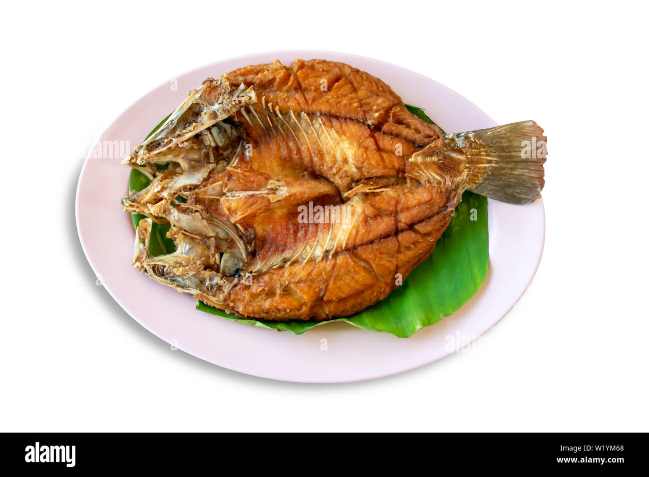 Isolierte fried snapper Fischen auf Bananenblättern in Teller auf einen weißen Hintergrund mit Freistellungspfaden. Stockfoto