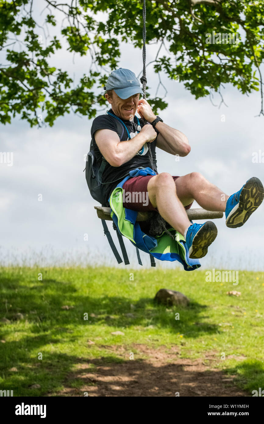 Männer in Shorts mit Spielen auf einem Seil schwingen. Stockfoto