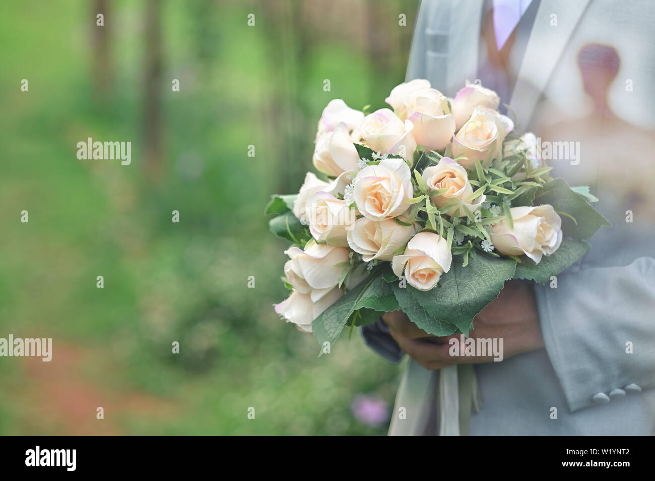 Bräutigam mit einem Blumenstrauß auf Händen mit Snap Shot auf der Hochzeit. Stockfoto