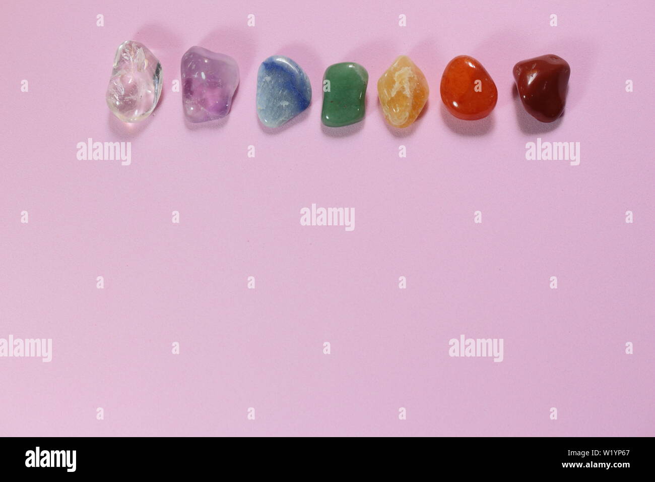 Chakra Healing Stones und ein Blatt auf Rosa tausendjährigen Hintergrund mit Platz für Text kopieren Stockfoto