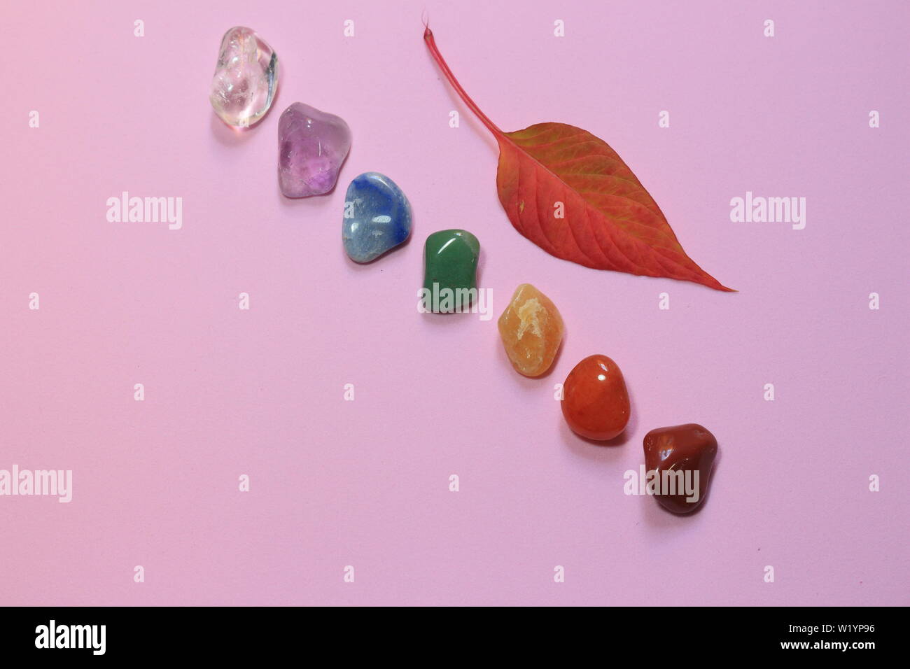 Chakra Healing Stones und ein Blatt auf Rosa tausendjährigen Hintergrund mit Platz für Text kopieren Stockfoto