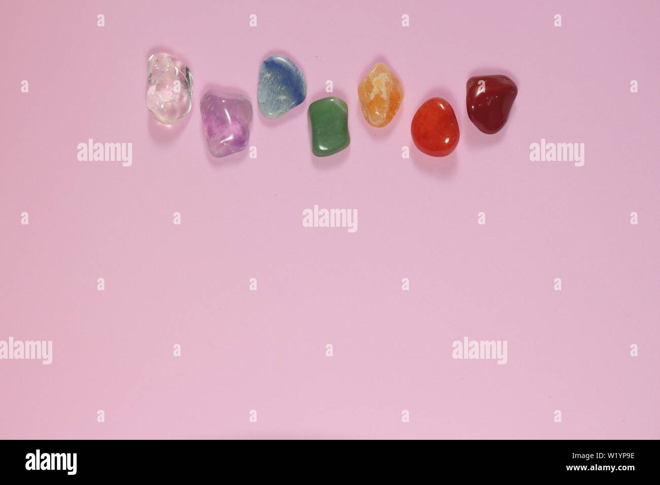 Chakra Healing Stones und ein Blatt auf Rosa tausendjährigen Hintergrund mit Platz für Text kopieren Stockfoto