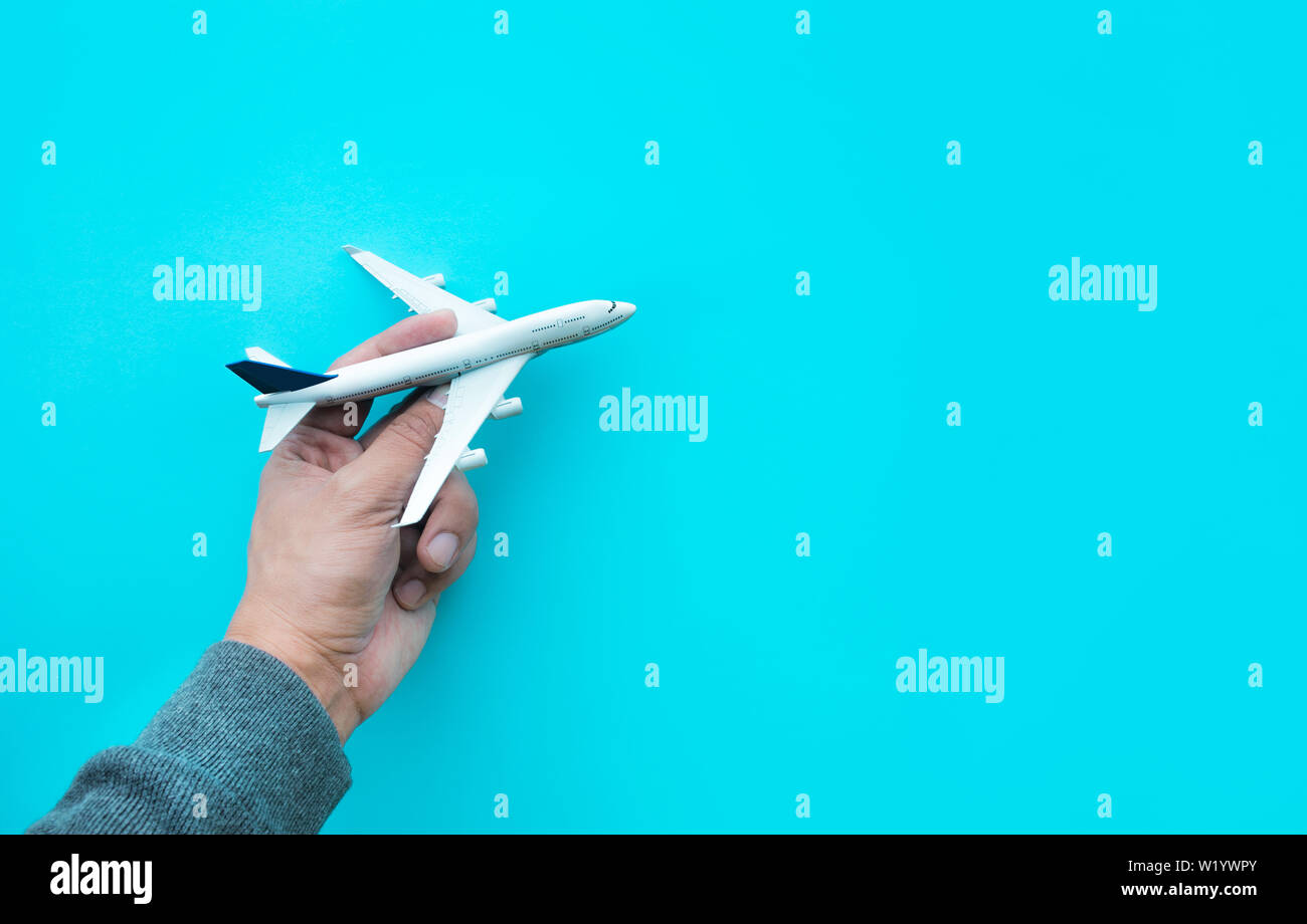 Männliche Hand Modell Flugzeug, Flugzeug auf blauen Pastelltönen Hintergrund. Stockfoto
