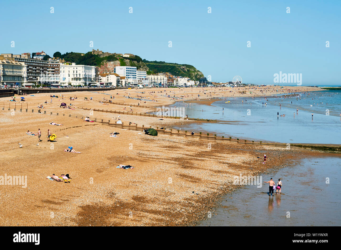 Strand von Hastings, East Sussex, Großbritannien, im Juni, mit Massen am Strand und im Meer Stockfoto