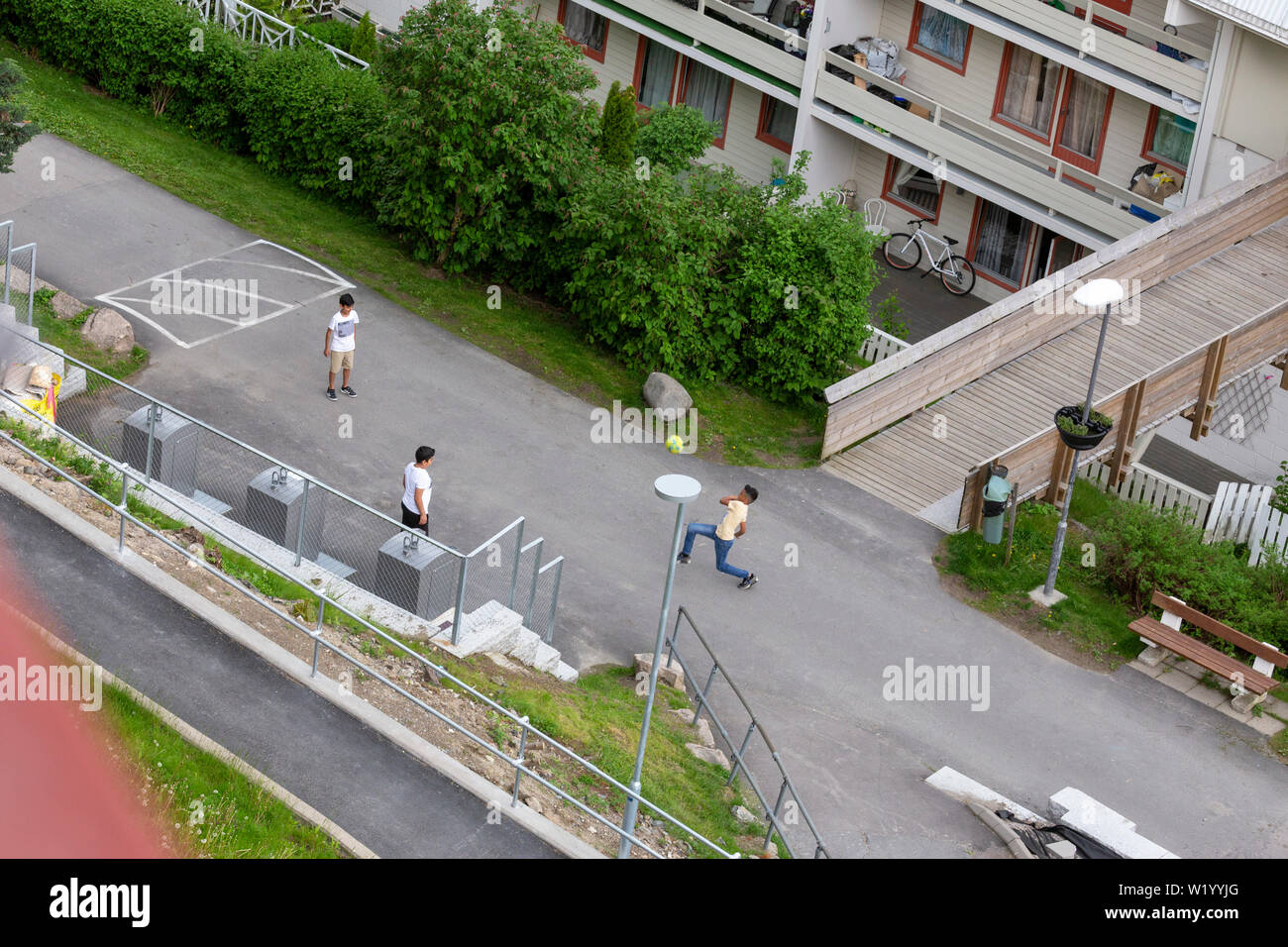 Drei Jungs spielen Fußball in der Nähe ihrer unban Apartment Wohnungen Stockfoto