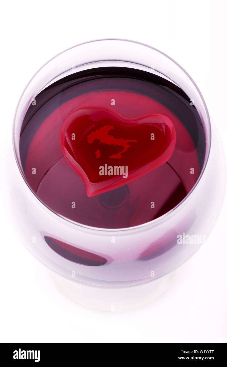 Glas Rotwein von oben gesehen, in dem schwimmt die Silhouette eines Herzen mit einer Zeichnung des Italienischen Karte Stockfoto