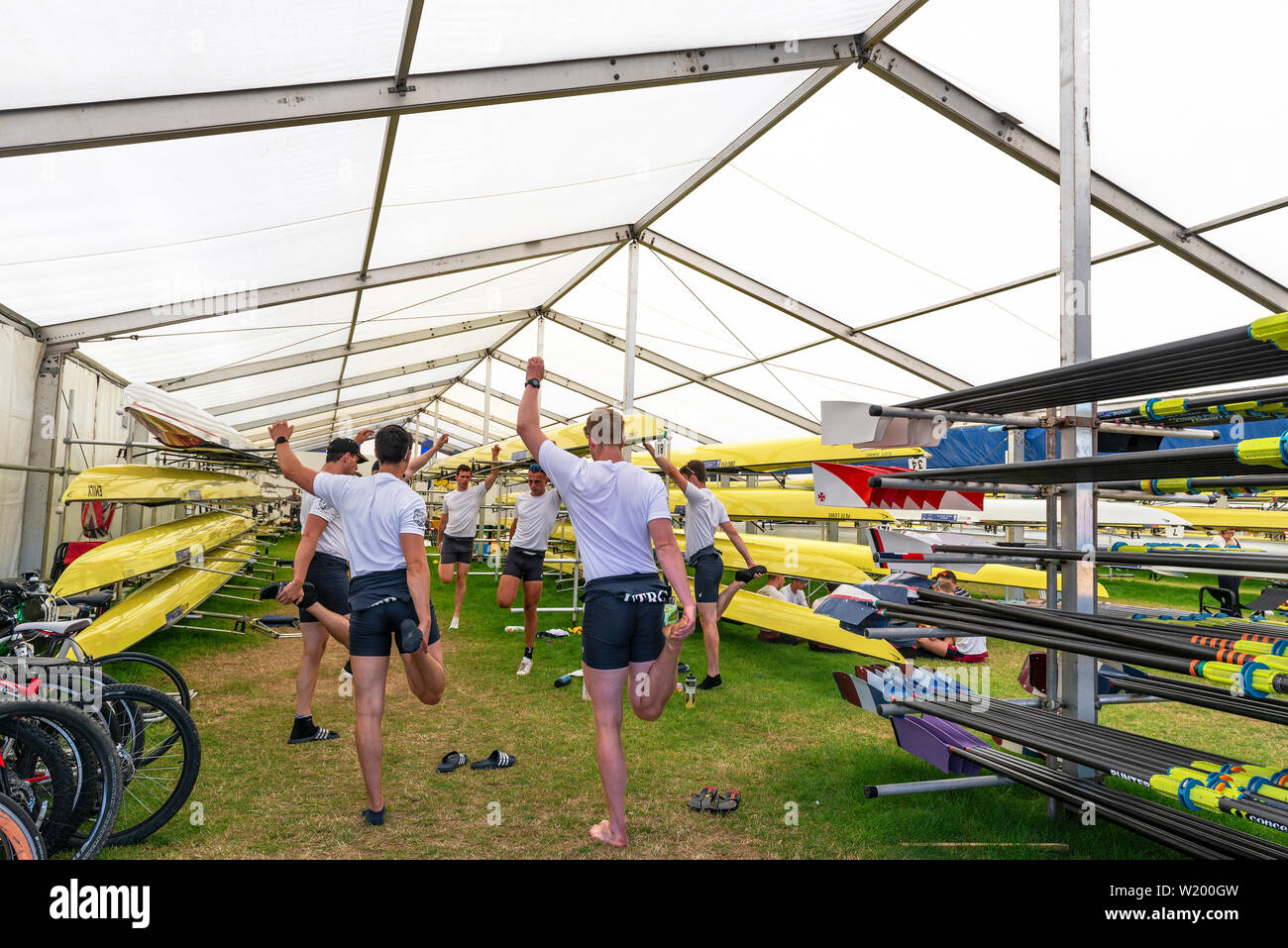 Henley on Thames, Berkshire, Großbritannien. 4. Juli 2019. Henley Royal Regatta. Upper Thames Rowing Club Team limbering mit erstreckt sich im Boot Zelt vor dem Rennen in der Themse Challenge Cup. Kredit Gary Blake/Alamy Live Stockfoto