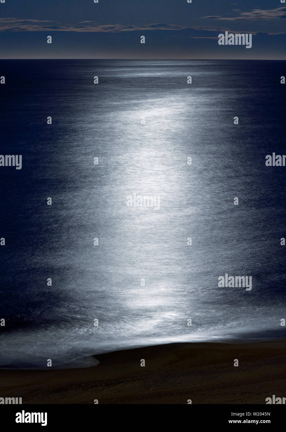 Mondschein reflektiert über die Wellen entlang der Küste bei Dämmerung n Virginia Beach, Virginia. Stockfoto