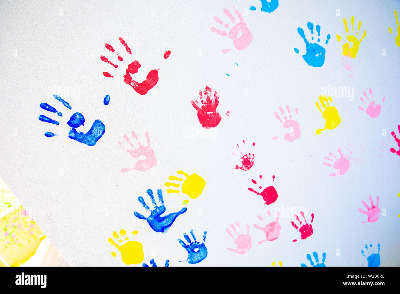 Bunte hand druckt der Hände auf weißer Wand Hintergrund isoliert. Kinder Handabdrücke auf der Schule an der Wand Stockfoto