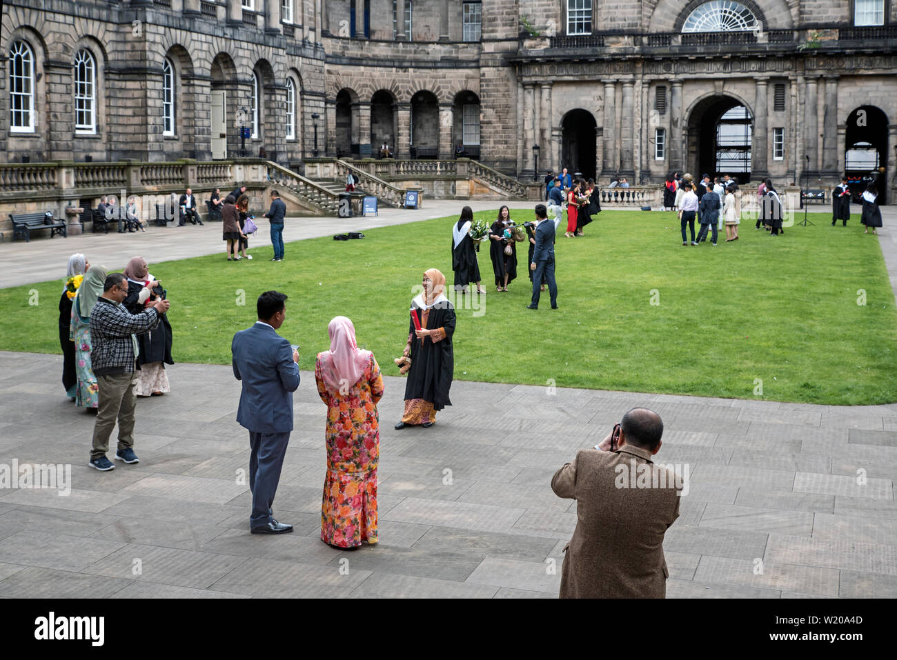 Asiatische Studenten von der Universität von Edinburgh Abschluss posieren für Fotos mit Familie und Freunden in der Quad der Alten Hochschule auf South Bridge. Stockfoto