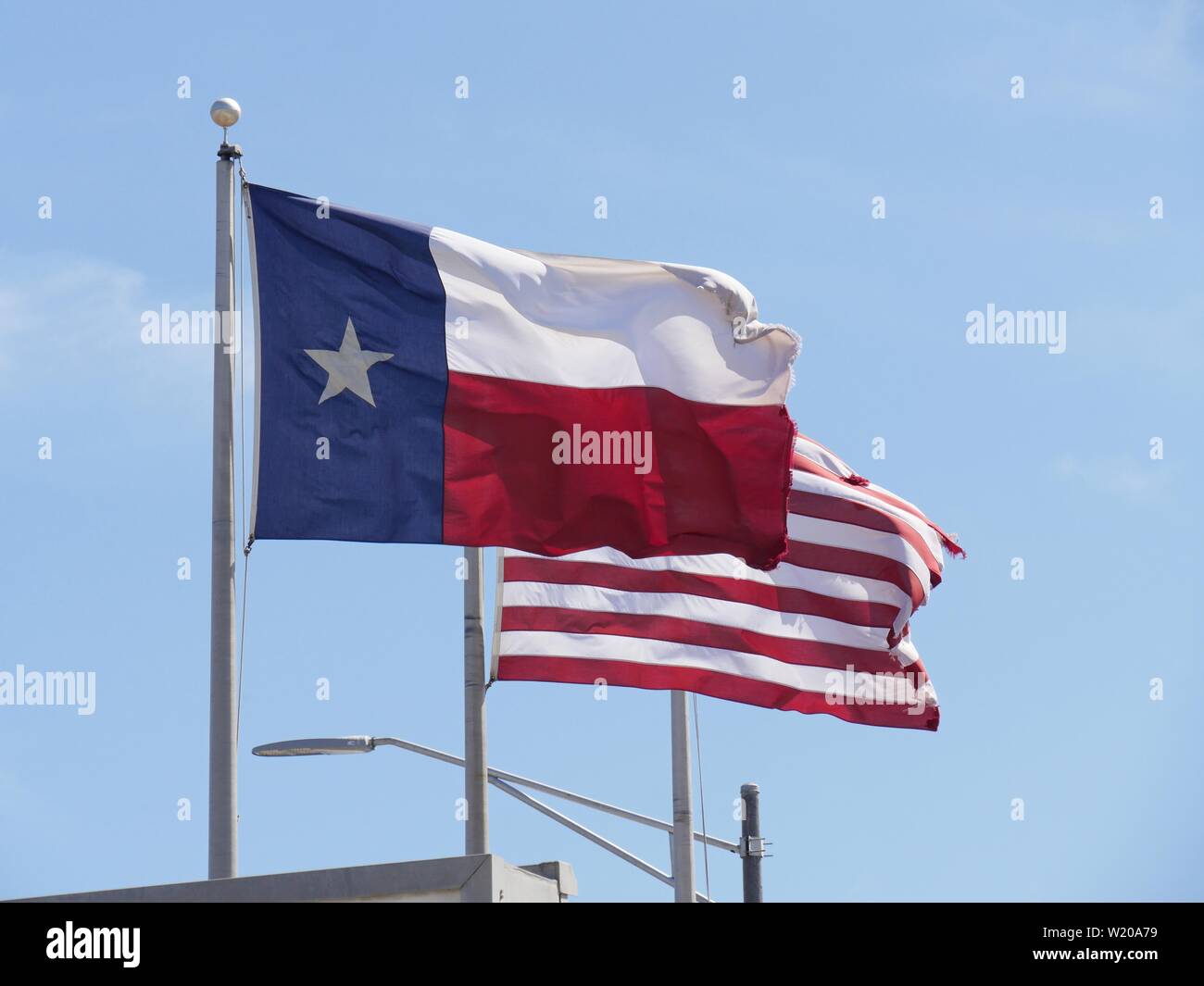 Nahaufnahme der Flaggen von Texas und den Vereinigten Staaten von Amerika, aus ihren Polen. Stockfoto