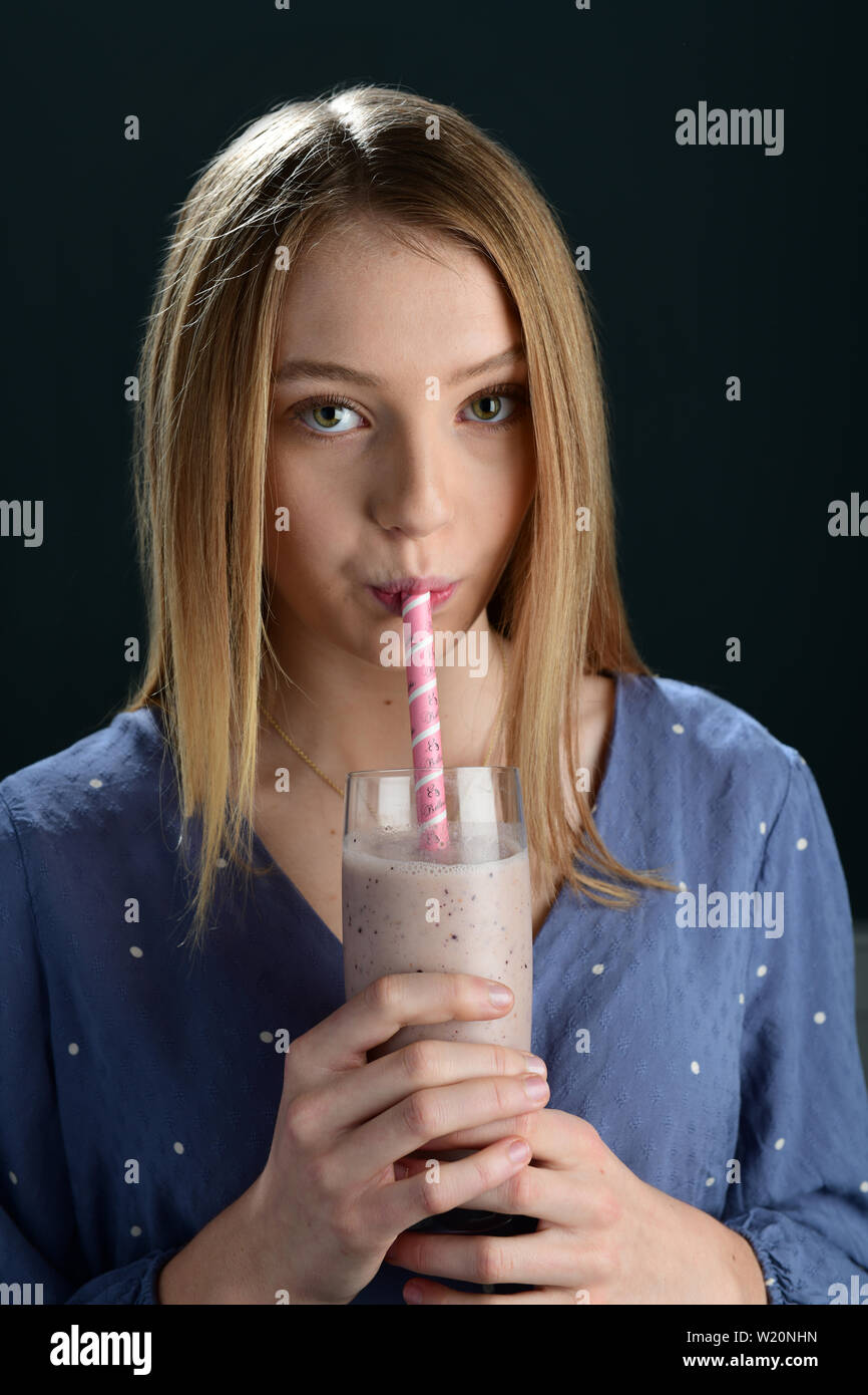 Mädchen trinken von nicht biologisch abbaubaren Kunststoff Papier Trinkhalme Stroh Stockfoto