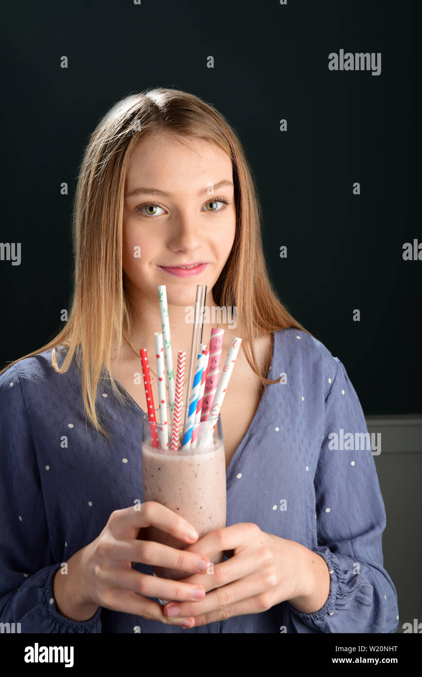 Mädchen trinken von nicht biologisch abbaubaren Kunststoff Strohhalme, Papier und Glas Stockfoto