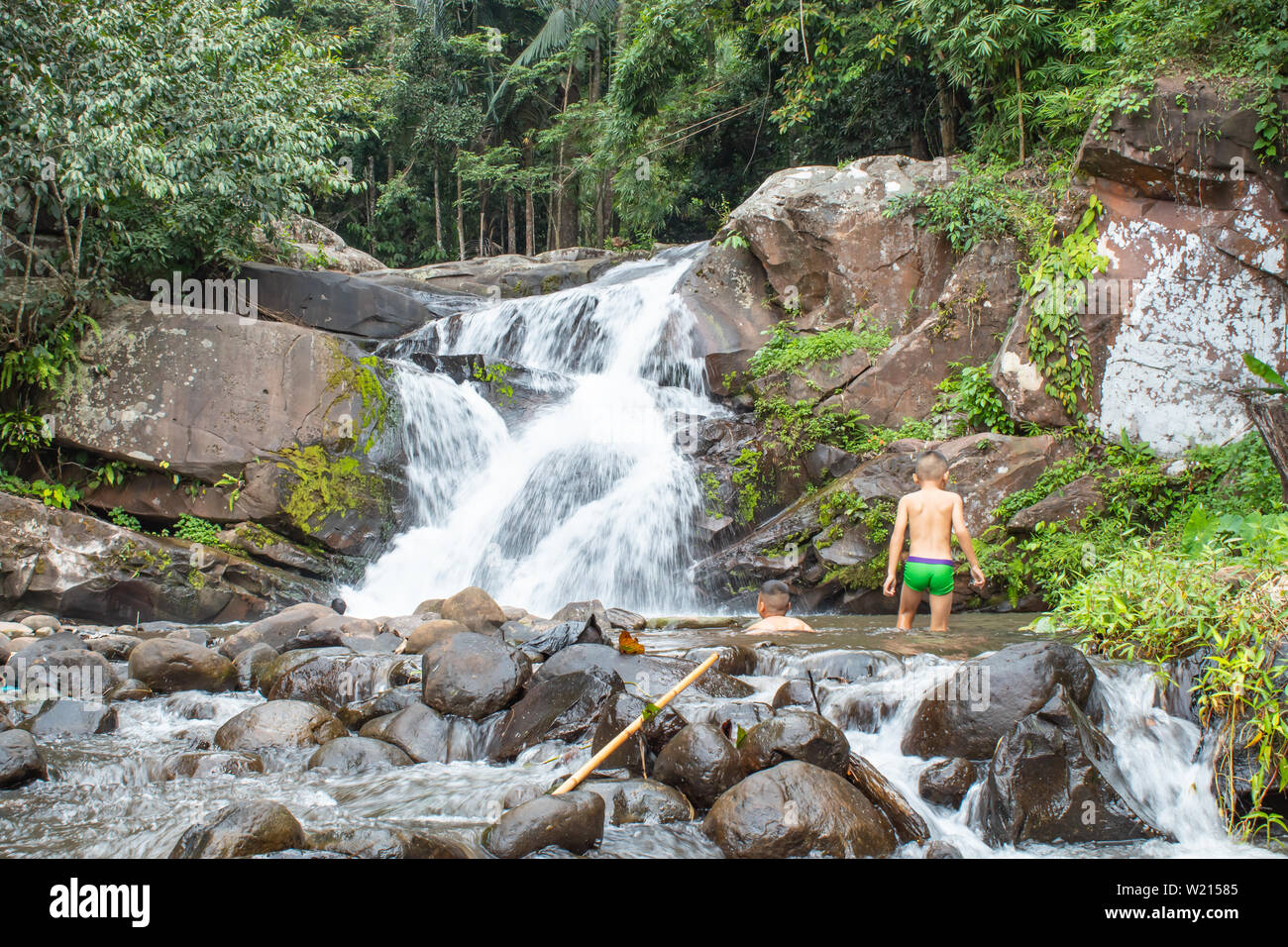 Die Jungen spielen am Wasserfall, der fließt von den Bergen herab. im Phu SOI DAO Wasserfall in Loei, Thailand. Stockfoto