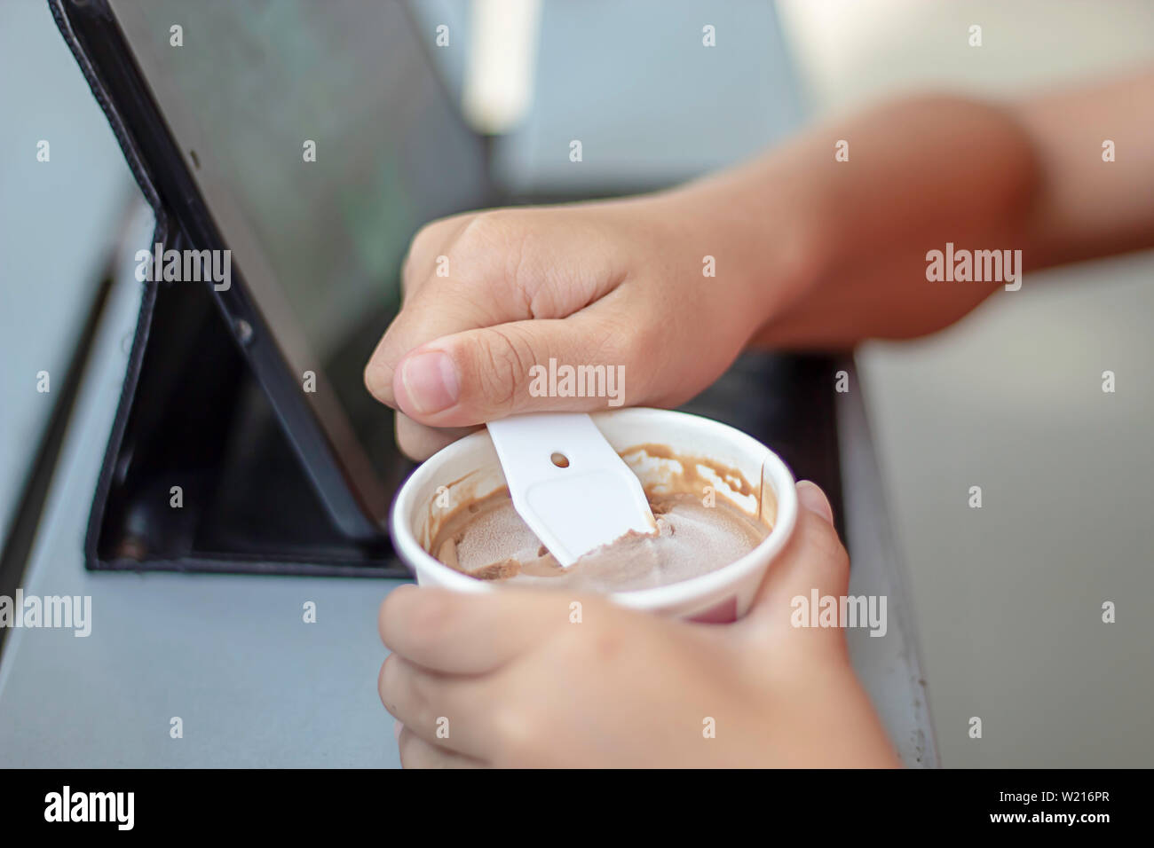 Hand junge halten sie die Löffel Eisportionierer in eine Tasse. Stockfoto