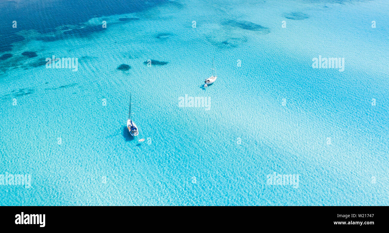 Ansicht von oben, atemberaubenden Blick auf einige Boote segeln auf einem schönen türkisklares Wasser. Spiaggia La Pelosa (Pelosa Strand) Stintino, Sardinien Stockfoto