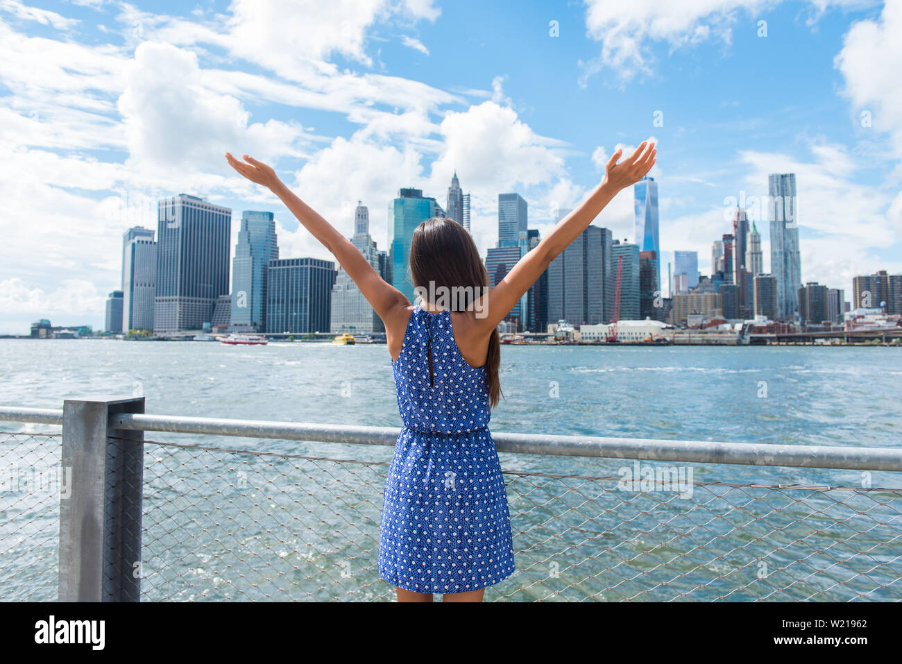 Gerne freie Frau Jubel in NYC New York City städtischen Skyline mit den Armen in den Himmel gehoben. Erfolg im Beruf, die Zielerreichung oder unbeschwerte Freiheit erfolgreichen städtischen person Konzept. Stockfoto