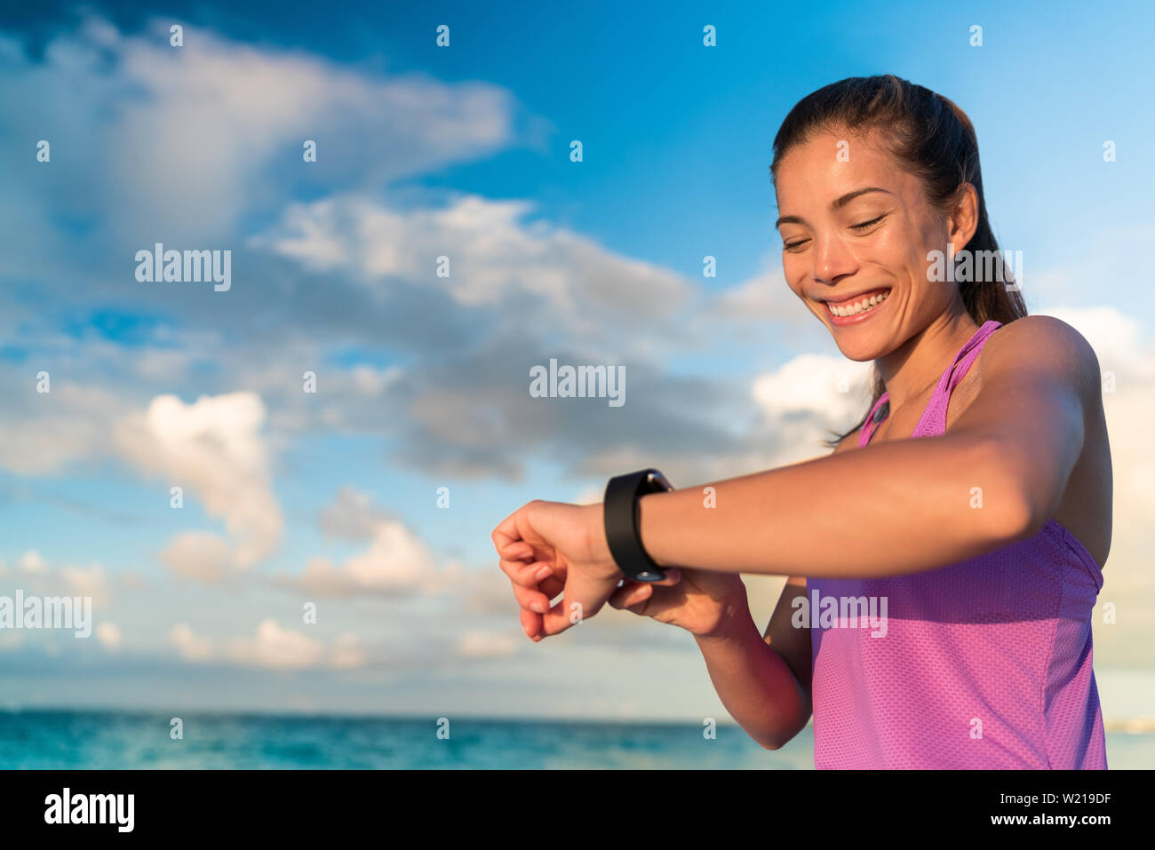 Aktive Mädchen mit Fitness tracker Smart watch Jogging auf Sommer Natur bei Gesundheitsdaten auf der Suche während der sportlichen Aktivität Berühren des Bildschirms des Ihr erobert. Stockfoto