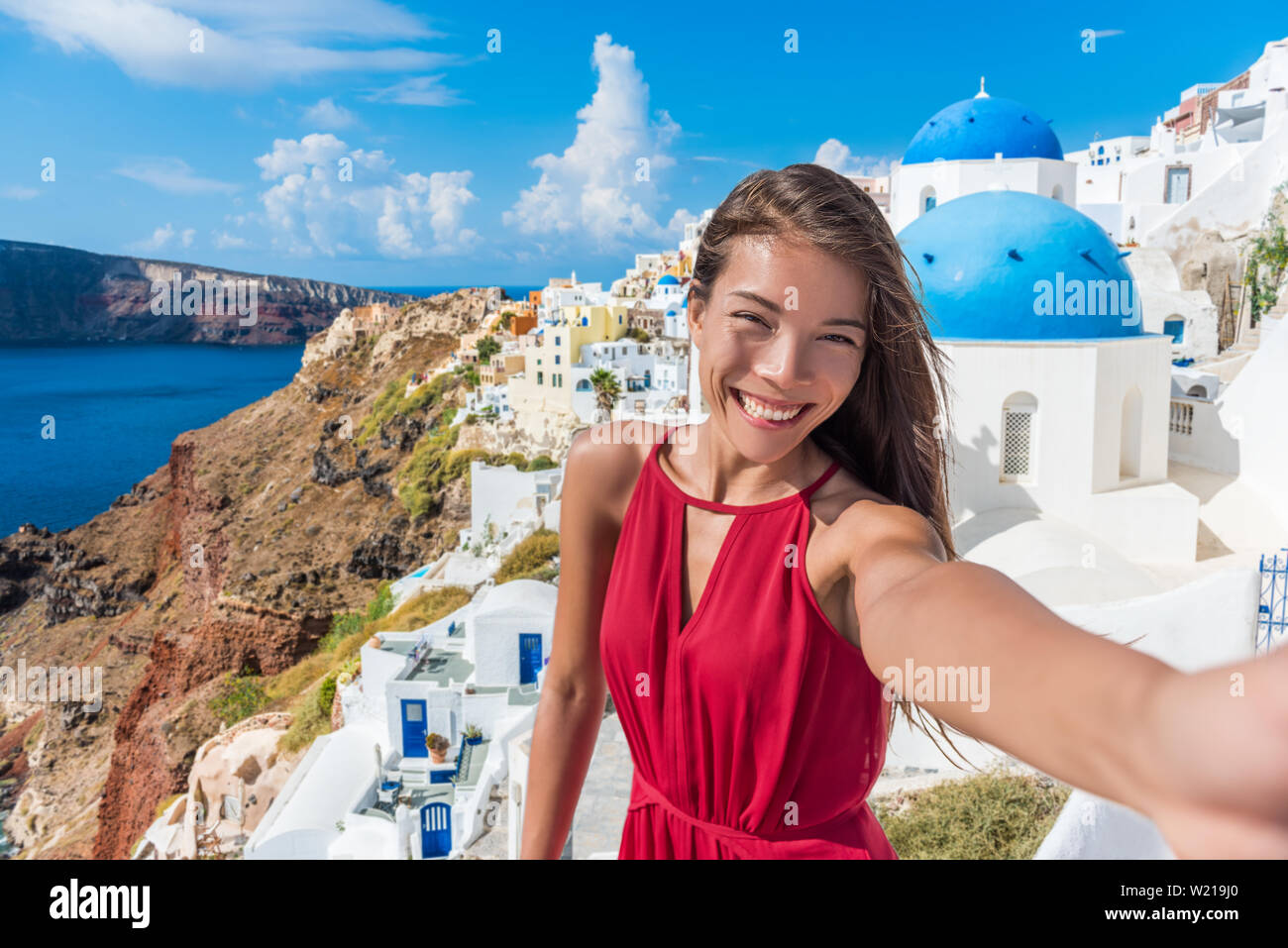 Europa reisen selfie asiatische Frau in das Dorf Oia, Santorini. Cute glücklich lächelnde Tourist girl Self-portrait Bild mit Smartphone im Sommer Urlaub in bekannten europäischen Ziel, Griechenland. Stockfoto