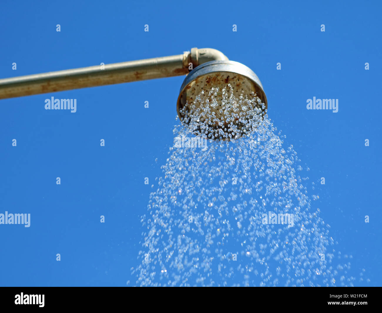 Nahaufnahme, Dusche im Freien Kopf mit Wassertropfen auf den blauen Himmel Hintergrund Stockfoto