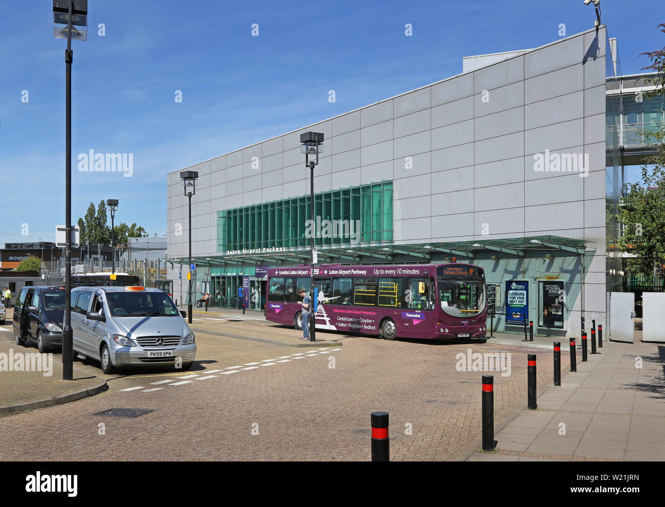 Luton Airport, London. Passagiere am Bahnhof Luton Airport Parkway warten auf den Shuttlebus zum Flughafen Terminal. Neue DART-Bahn Link öffnet in 2021. Stockfoto
