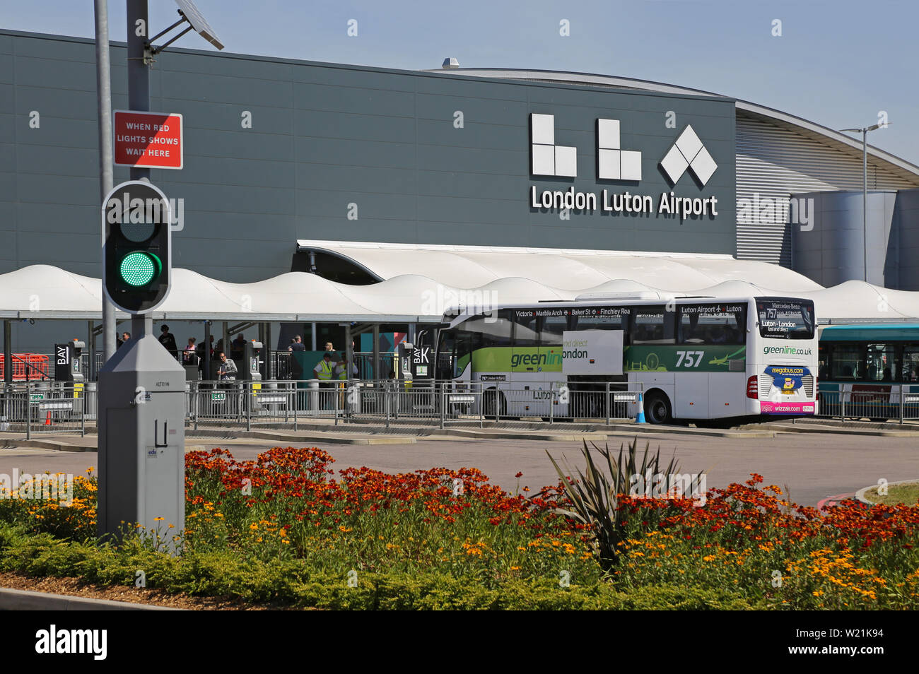 Luton Airport, London. Passagier drop-off-Bereich und der Bushaltestelle vor dem Terminal Gebäude - mit neuem Logo (Sommer 2019) Stockfoto