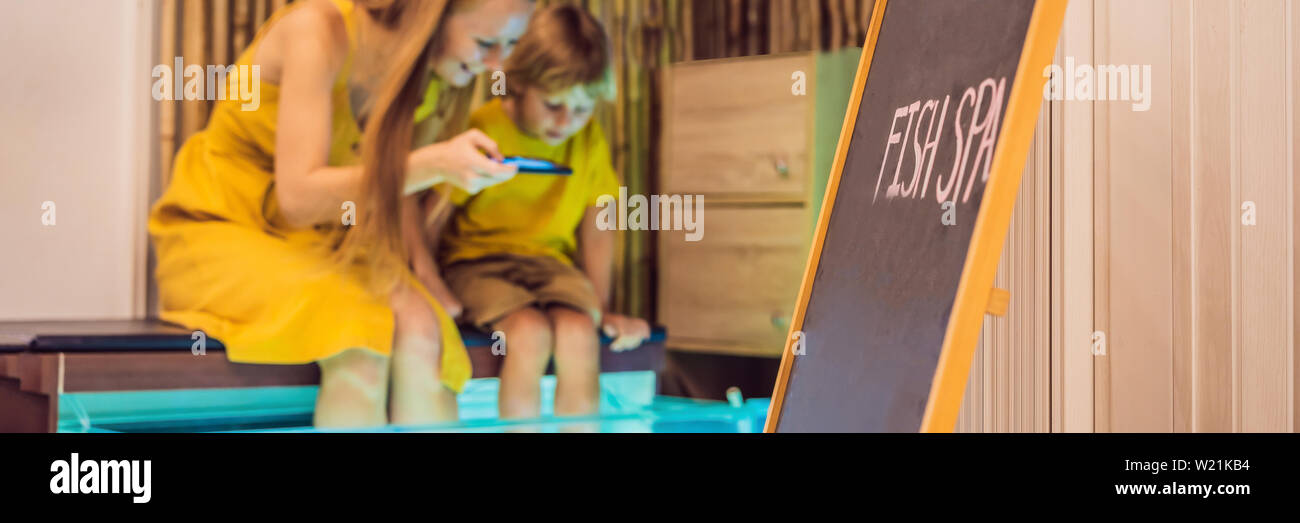 Mutter und Sohn am Fish Spa BANNER, LANGE FORMAT Stockfoto