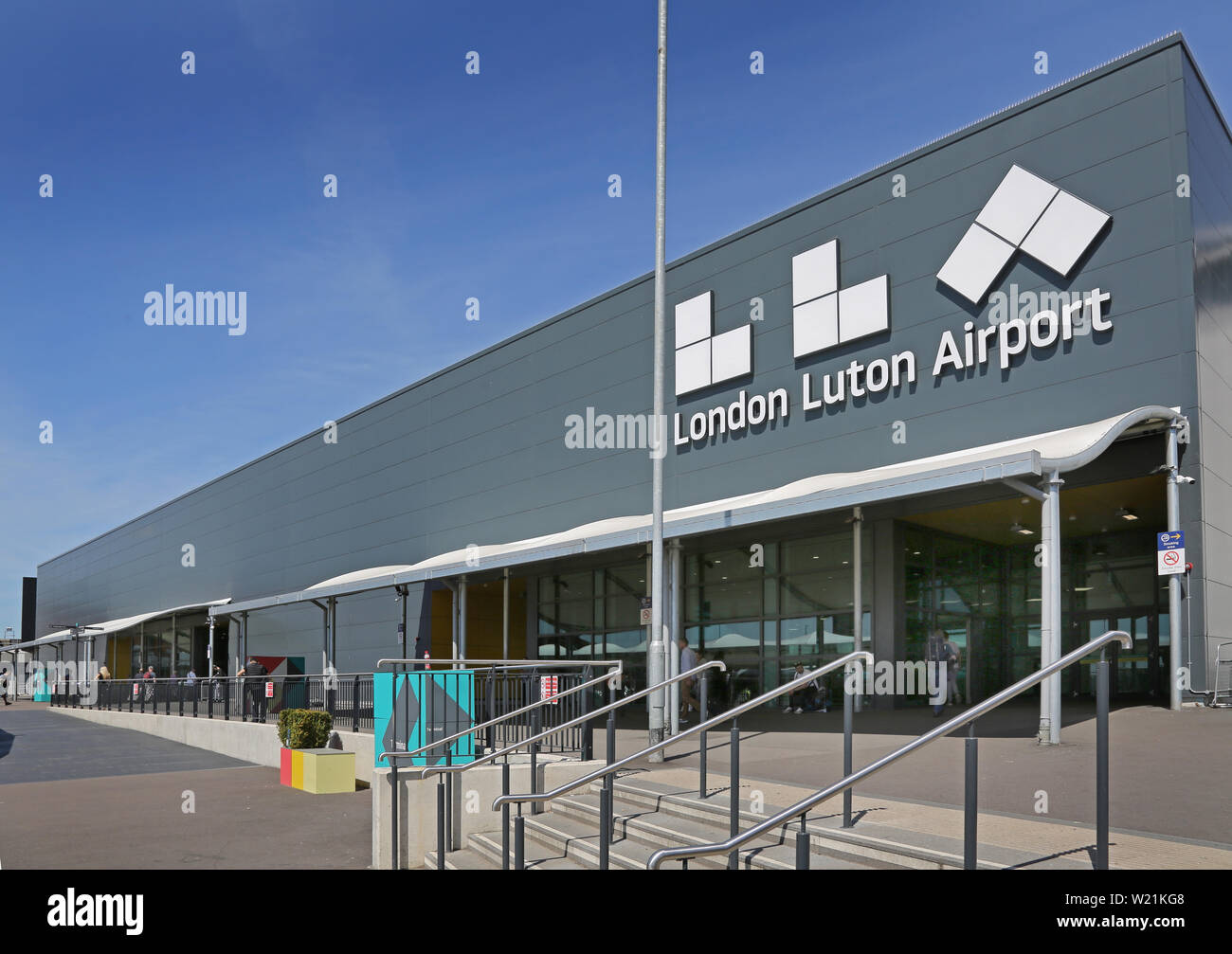 Luton Airport, London. Passagier drop-off-Bereich und der Eingang zum Hauptterminal - mit neuen Flughafen Logo (Sommer 2019) Stockfoto