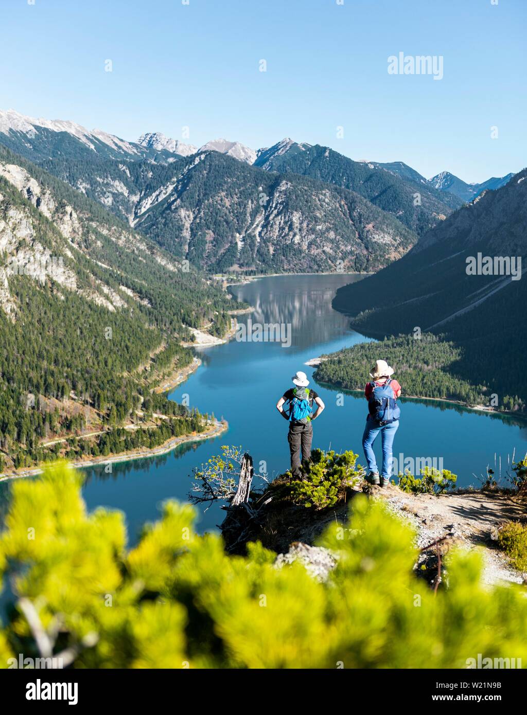 Zwei Wanderer Blick in die Ferne über den See Plansee, von Bergen, Schonjochl, Plansee, Tirol, Österreich an der Rückseite umgeben. Stockfoto