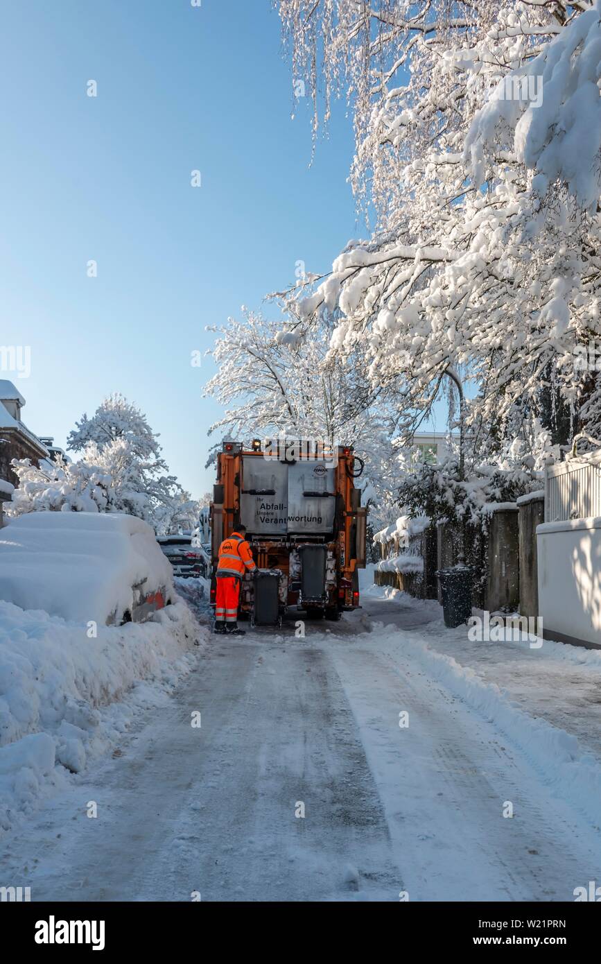 Garbage Collection im Schnee in engen Straßen mit schneebedeckten Autos, München, Oberbayern, Bayern, Deutschland Stockfoto