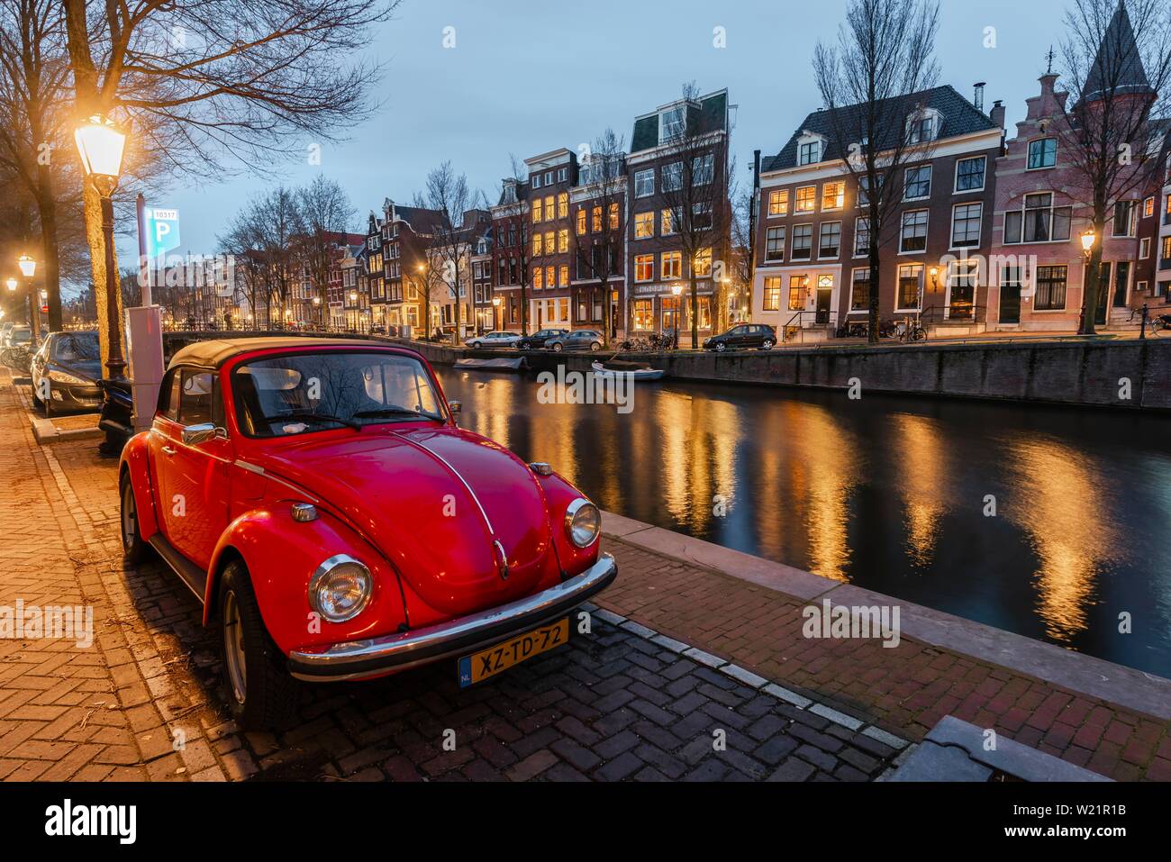 Alten VW Käfer Parks am Kanal, historische Häuserzeile an einem Kanal in der Dämmerung, Amsterdam, Nordholland, Niederlande Stockfoto