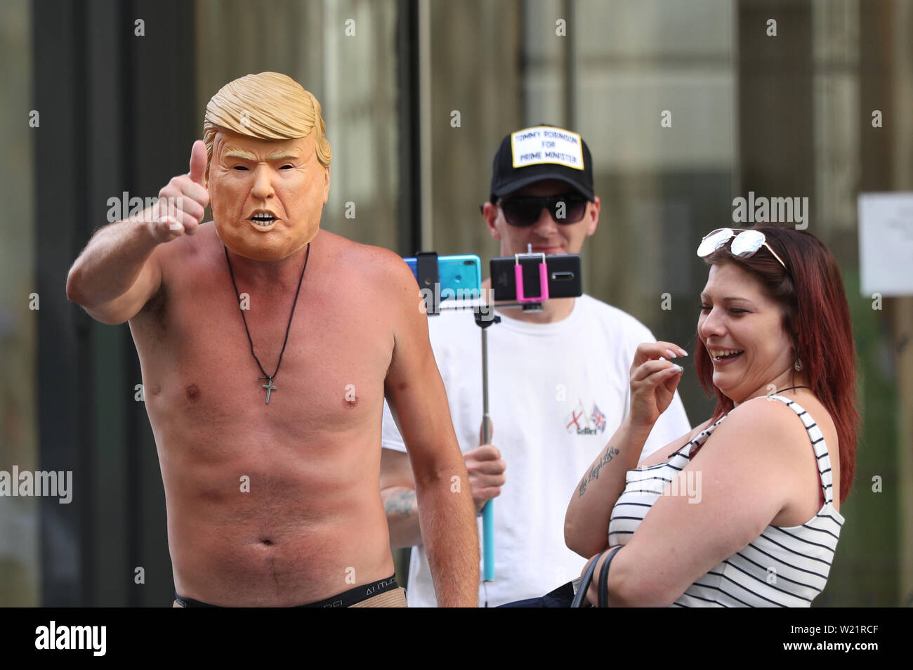 Unterstützer von Tommy Robinson, eine trägt ein Donald Trump Maske, für seine Ankunft im Old Bailey in London, wo er aufgrund einer Anklageerhebung wegen angeblicher Missachtung des Gerichts zu warten. Stockfoto