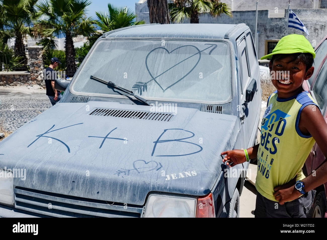 Dirty Fiat Panda mit eine liebe Nachricht auf seiner Vorderseite Glas geparkt mit Latin boy Spaß daneben. Griechenland Stockfoto