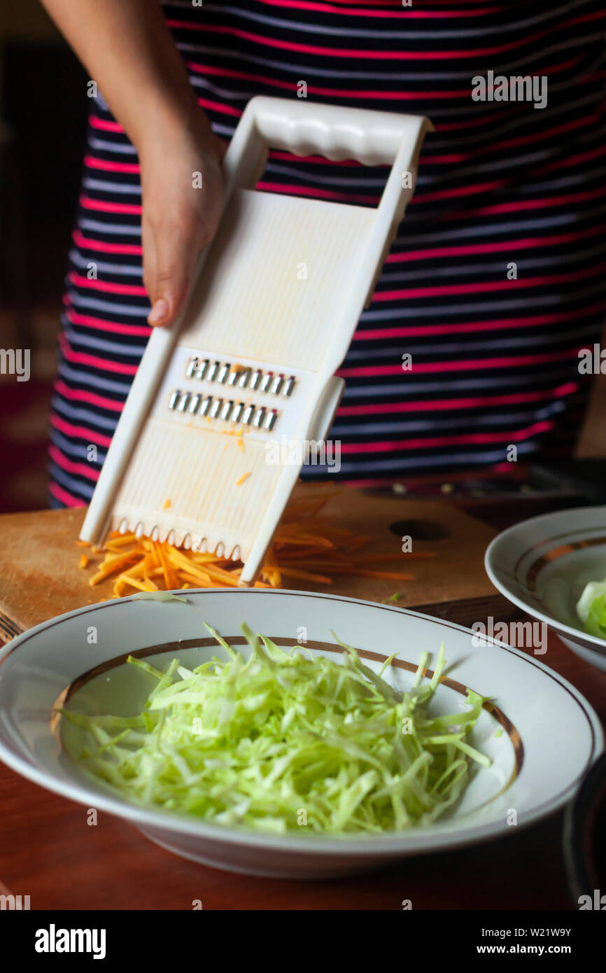 Hausfrau einen Salat aus frischem gesunden Gemüse. Junge Frau, Salat in der Küche Stockfoto