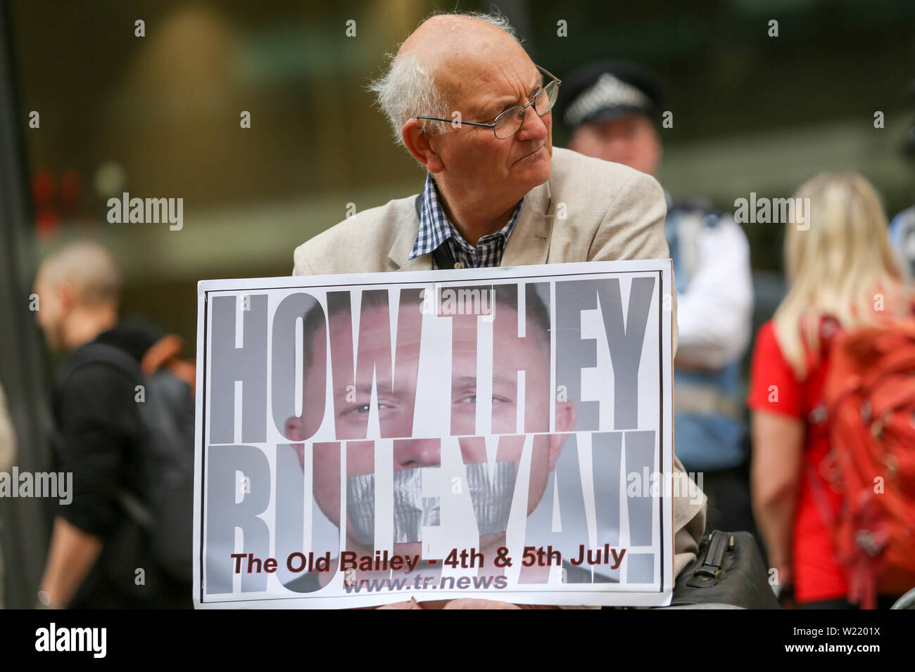 Old Bailey, London, Großbritannien. Juli 2019. Älterer Mann mit einem Protestplakat mit der Aufschrift „WIE SIE YA BEGRABEN!“ Während einer öffentlichen Demonstration vor dem Old Bailey, London. Das Schild bezieht sich auf TR News und datiert vom 4. Und 5. Juli. Polizei und andere Demonstranten im Hintergrund sichtbar. Tommy Robinson, echter Name Stephen Yaxley-Lennon, außerhalb des Old Bailey, wo Robinson wegen angeblicher Verachtung des Gerichts erscheint, weil er Personen filmt, die an einem Strafprozess beteiligt waren und das Filmmaterial in sozialen Medien ausstrahlt. Penelope Barritt/Alamy Live News Stockfoto