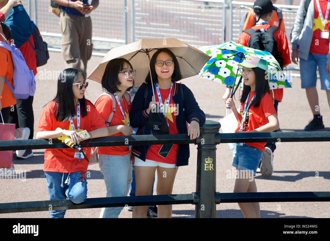 London, England, UK. Japanische Schulmädchen an einem heißen, sonnigen Tag draußen Buckingham Palace Stockfoto