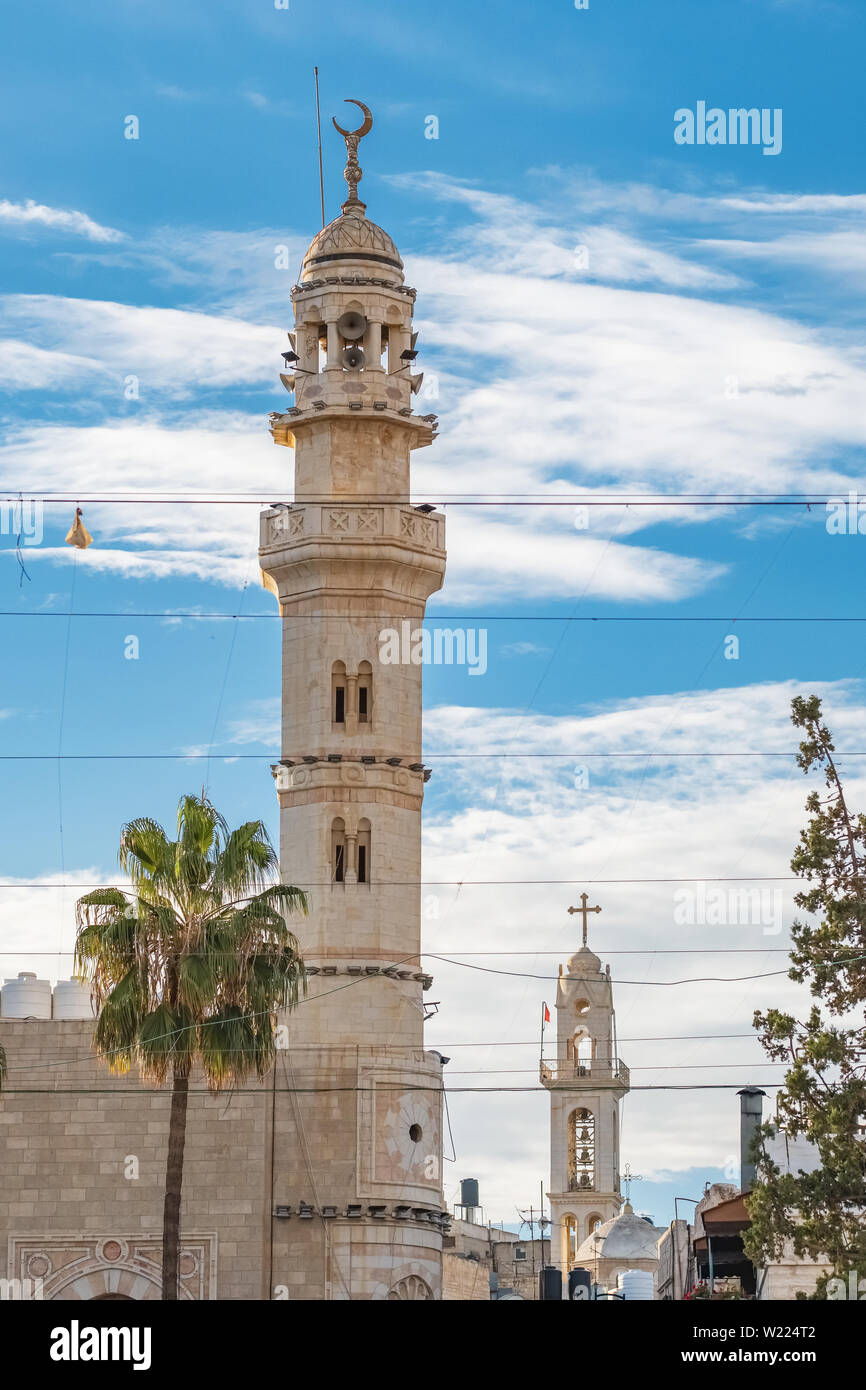 Muslimisches Minarett und christliche Kirche im Hintergrund in Bethlehem, Palästina. Stockfoto